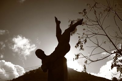 Low angle view of silhouette statue against sky