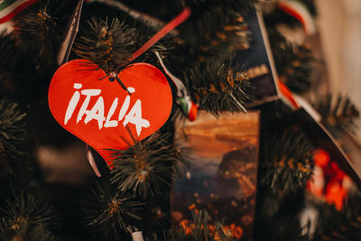 Christmas toy red heart with text italy hanging on the christmas tree. festive winter background