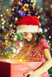 Portrait of young woman holding christmas tree