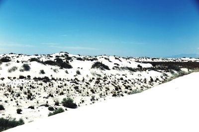 Scenic view of snow covered mountains against clear sky