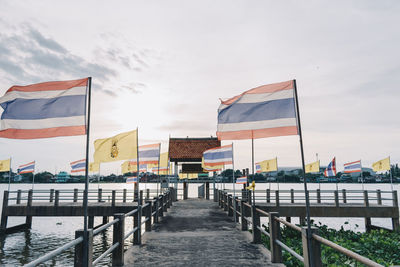 View of flags at pier against sky