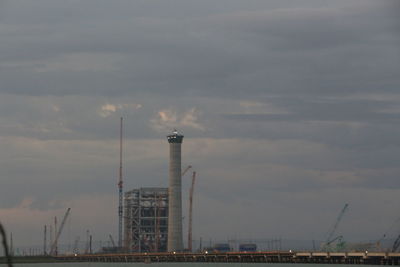 Smoke emitting from factory against sky