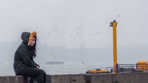 Woman looking at camera against sky