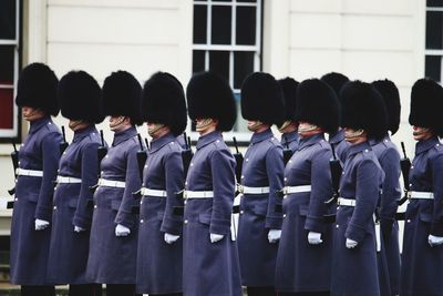 Soldiers wearing blue uniform in parade against building