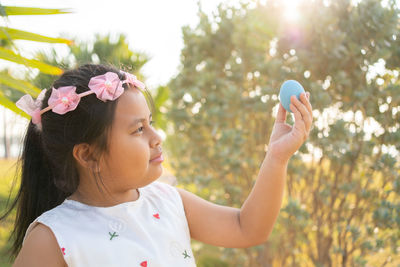 Portrait of girl with pink flowers against blurred background