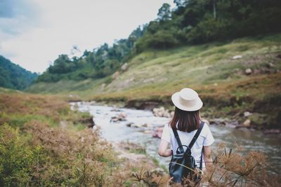 Full length of woman looking at view of waterfall