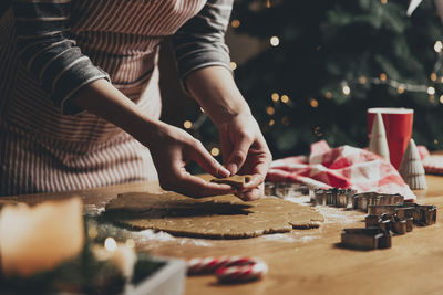 Midsection of woman with cookies on table