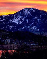 Scenic view of snowcapped mountains against sky at sunset