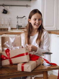 Portrait of young woman using mobile phone while sitting at home