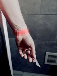 Close-up of woman holding hand on tiled floor