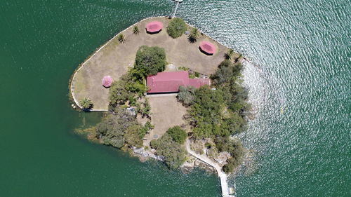 Directly above shot of houses and trees on island surrounded by sea