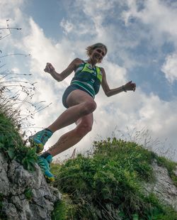 Low angle view of person jumping against sky