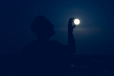 Rear view of silhouette man standing against sky