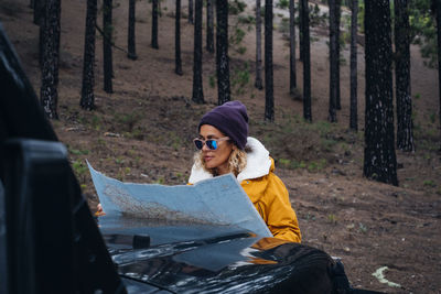 Portrait of young woman standing in forest