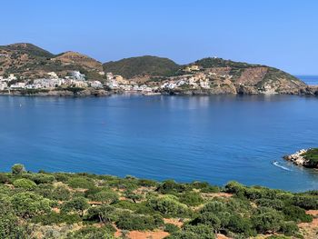 Scenic view of sea and mountains against blue sky