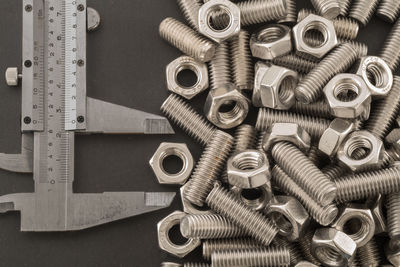 High angle view of nuts and bolts with ruler on table