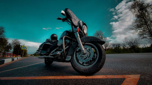 Motorcycle on road against sky in city