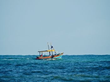 Sailboat sailing in sea against clear sky