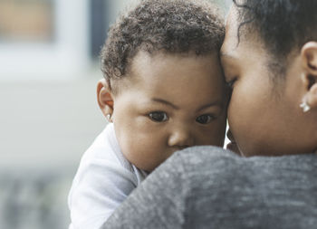 Close-up of girl carried by mother outdoors