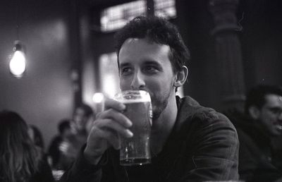 Portrait of man drinking beer glass in restaurant