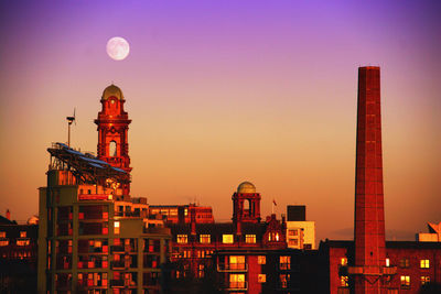 Illuminated cityscape against sky at dusk