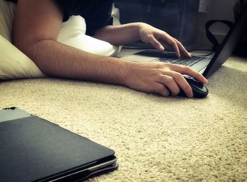 Midsection of woman using smart phone while sitting on table