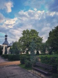 Trees by building against sky