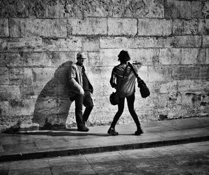 Rear view of people walking on wall