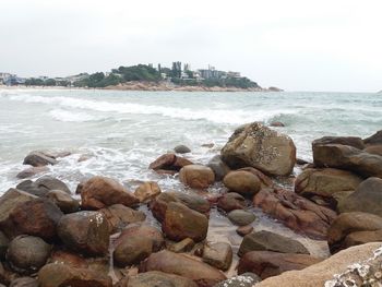 Rocks on beach against sky