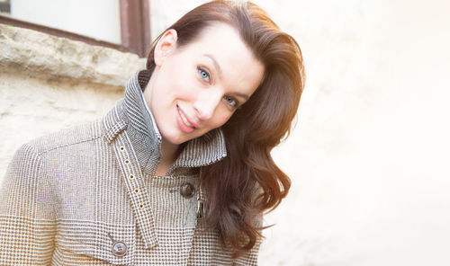 Portrait of woman standing against wall