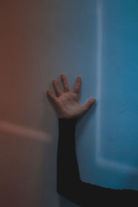 Close-up of hand against wall