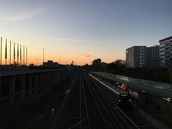 High angle view of railroad tracks amidst buildings in city during sunset