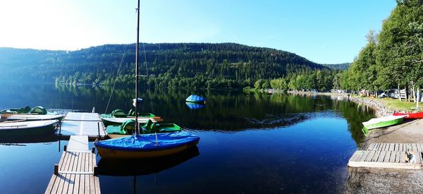 Boats moored in lake against sky