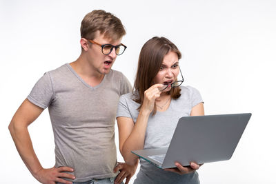 Young man using smart phone against white background