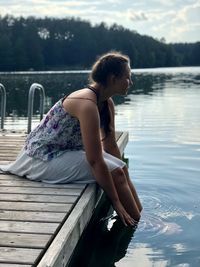 Woman sitting by swimming pool in lake