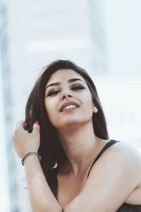 Portrait of smiling young woman in hand in hair