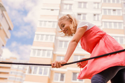 Low angle view of girl against building