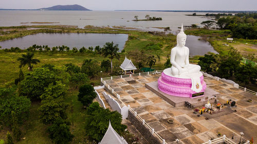 Statue by temple against sky