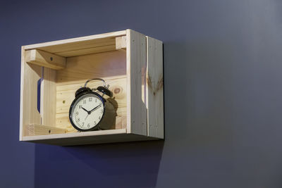 Close-up of clock on table against wall