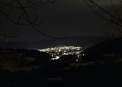 Illuminated city against sky at night