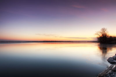 Scenic view of lake against sky at sunset