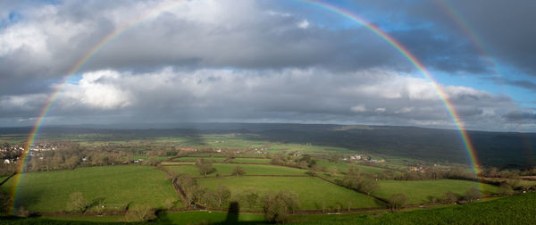 Scenic view of rainbow over land against sky