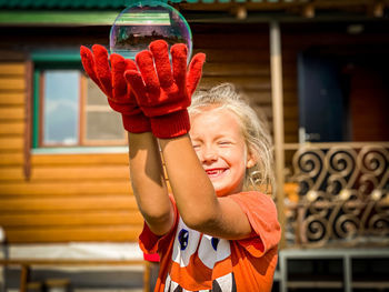 Portrait of a smiling girl holding baby outdoors