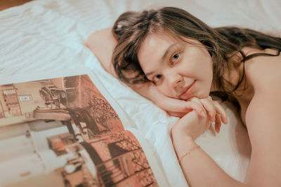 High angle view of young woman lying on bed at home