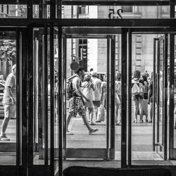 People on street seen through glass doors of building