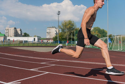 Low section of man exercising on field