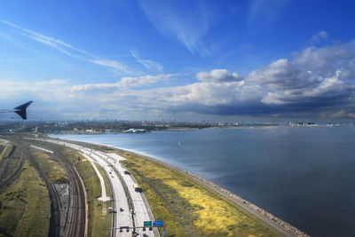Panoramic view of road by sea against blue sky