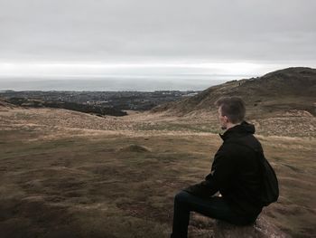 Rear view of man on beach against sky