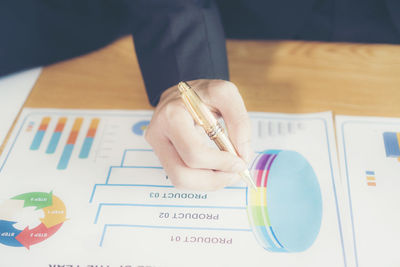 Close-up of businessman working over graph on table