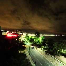 Cars on road against cloudy sky